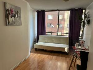 sala de estar con sofá blanco frente a una ventana en Hotel Smart Bellas Artes, en Santiago