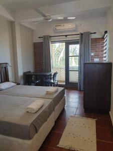 a bedroom with two beds and a table with a piano at Janishi Residencies in Negombo