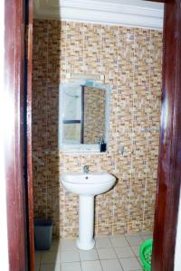 a bathroom with a white sink and a mirror at Home By Dina'Sty in Yaoundé