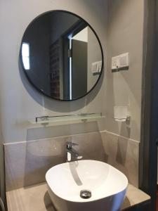 La salle de bains est pourvue d'un lavabo blanc et d'un miroir. dans l'établissement Janishi Residencies, à Negombo