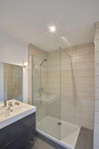 W łazience znajduje się szklana kabina prysznicowa i umywalka. w obiekcie Appart Balcon Clim 10 mins Disneyland 2CHB QuartierChic w mieście Serris