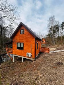una pequeña casa de madera al lado de un campo en Domek na Skarpie 2, en Joniec