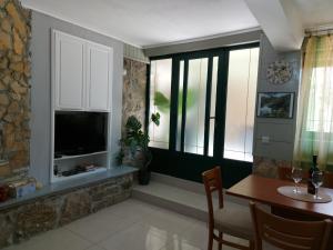 sala de estar con mesa, TV y ventana en Apartment Balinovaca, en Skradin