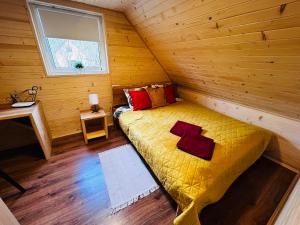 a bedroom with a bed in a wooden cabin at Domek na Skarpie 2 in Joniec