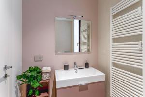 y baño con lavabo blanco y espejo. en Varesina Suite - Pavia City Center - by Host4U, en Pavia