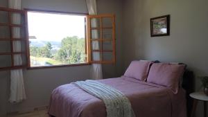 - une chambre avec un lit et une fenêtre dans l'établissement Casa flores do campo, à Campos do Jordão