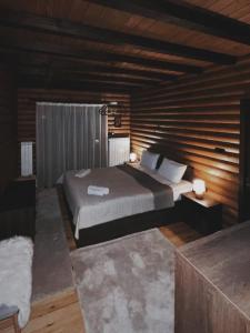 1 dormitorio con 1 cama y pared de madera en Guest House Recharge en Govedartsi