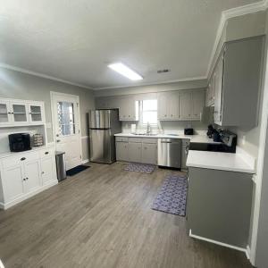 eine große Küche mit weißen Schränken und Küchengeräten aus Edelstahl in der Unterkunft Deodara Cottage in Augusta