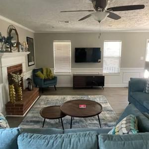 ein Wohnzimmer mit einem blauen Sofa und einem Tisch in der Unterkunft Deodara Cottage in Augusta