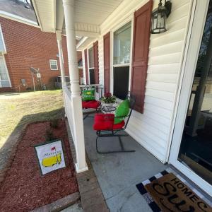 eine Veranda mit 2 Stühlen und einem Tisch auf einem Haus in der Unterkunft Deodara Cottage in Augusta