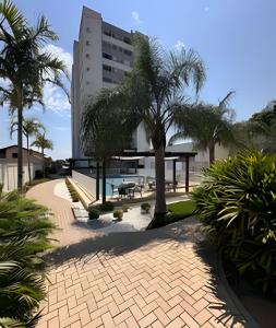een gebouw met palmbomen en een stenen loopbrug bij APTO frente mar com vista incrível e com piscina! in Piçarras