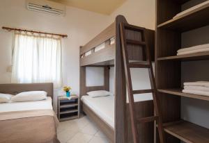 a bedroom with two bunk beds and a window at Lofos Kalamitsi in Kalamitsi