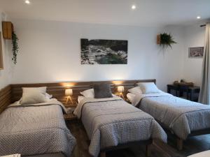 three beds in a room with lights on the wall at La Rose des Vents in Saint-Germain-sur-Morin