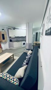 Habitación con 2 camas con almohadas y cocina. en Apartamento Centro NOVORT, en Gijón