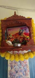 a wooden shelf with a bowl of flowers on it at Sri Viswanatham Guest House in Varanasi