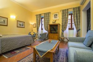 a hotel room with a bed and a couch and a table at La Casa Del Garbo - Luxury Rooms & Suite in Florence