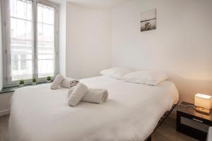 um quarto branco com 2 toalhas brancas numa cama em Centre-ville - calme -proche gare em Angoulême