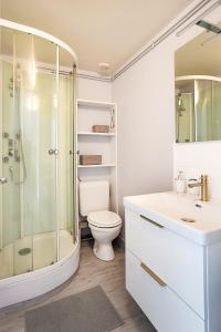 uma casa de banho branca com um chuveiro e um WC. em Centre-ville - calme -proche gare em Angoulême