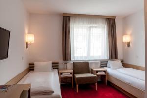 a hotel room with a bed and a chair at Gästehaus Brugger in Bregenz