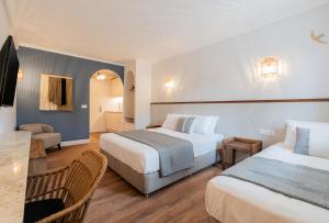 a hotel room with two beds and a table at Blue Paradise Studios in Argostoli