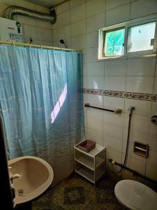 ein Bad mit einer Dusche, einem Waschbecken und einem WC in der Unterkunft Casa de playa in Santa Vitória do Palmar