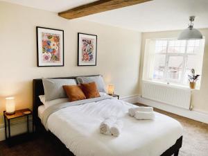 um quarto com uma cama grande e toalhas em Rear of Northway Court Farm em Tewkesbury