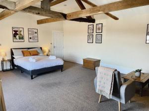 een slaapkamer met een bed, een tafel en een stoel bij Rear of Northway Court Farm in Tewkesbury