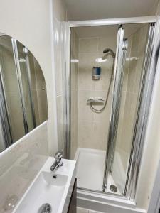 a white bathroom with a shower and a sink at Rear of Northway Court Farm in Tewkesbury +33 photos