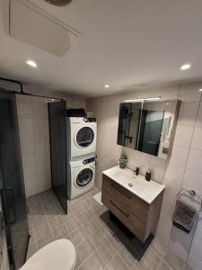 een badkamer met een wasmachine en een wastafel bij Wonderful appartement with a nice view. Parking! in Sola