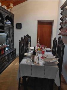- une table à manger avec un tissu de table blanc et des verres à vin dans l'établissement Monte da Bárbara, à Algoceira