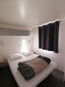 1 dormitorio con cama blanca y cortina negra en Le Moulin du Pont D'Aliès, en Axat