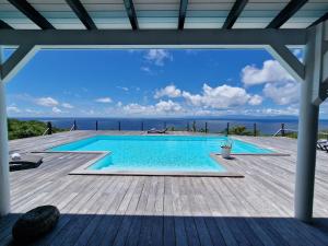 una piscina en una terraza con vistas al océano en Villa Horizon à Marie-Galante en Grand-Bourg