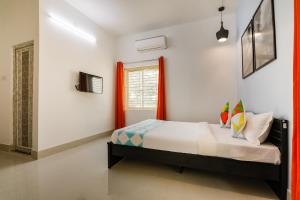 a bedroom with a bed and a window at OYO Flagship Saket Homes in Bhubaneshwar