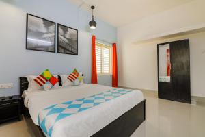 a bedroom with a large bed with colorful pillows at OYO Flagship Saket Homes in Bhubaneshwar