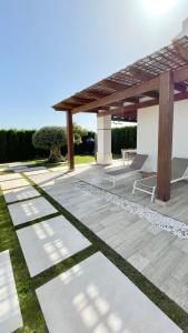 a patio with a wooden pergola and grass at HOUSE WITH PRIVATE GARDEN in Finestrat