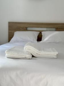 2 serviettes assises au-dessus d'un lit blanc dans l'établissement Cantinho do Vale - Oleiros, à Oleiros