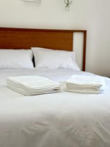 two white towels sitting on top of a white bed at Cantinho do Vale - Oleiros in Oleiros