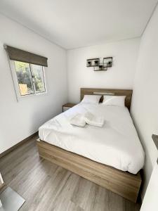 a bedroom with a bed with white sheets and a window at Cantinho do Vale - Oleiros in Oleiros