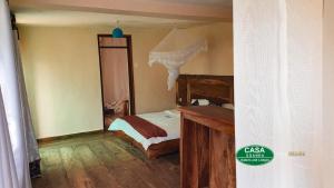 a bedroom with a bed and a wooden desk at Tourist Home in Mbale