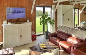 sala de estar con sofá y TV en Le Bois De La Fontaine, en Florimont-Gaumiers