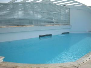 uma grande piscina com água azul num edifício em Rentasuite Lyon em Santiago
