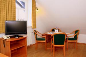 ein kleines Esszimmer mit einem Tisch und einem TV in der Unterkunft Gästehaus Musestieg in Thale