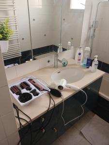 eine Badezimmertheke mit einem Waschbecken und einem Spiegel in der Unterkunft PARADIS CHAMBRES D'HÔTES PROCHE PARIS - AÉROPORT CHARLES DE GAULLE AIRPORT - PARC DES EXPOSITION VILLEPINTE - DYSNAYLAND PARIS. in Tremblay En France