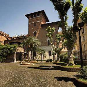 un gran edificio de ladrillo con árboles delante de él en Hotel Ercoli House en Roma