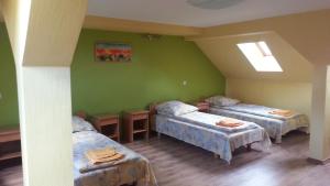 a room with three beds in a room with green walls at Ūdensputni in Tāšu-Padure