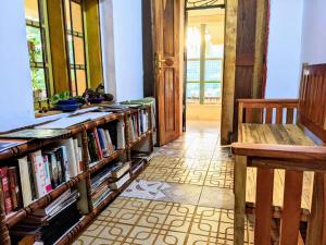 Zimmer mit Regalen mit Büchern und einer Bank in der Unterkunft Lushoto views cottage in Lushoto