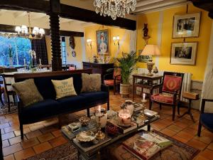 uma sala de estar com um sofá e uma mesa em Le Logis Fleurs et jardins de Pitry 
