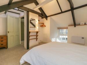a bedroom with a white bed and a window at Dunridge Cottage in Yelverton