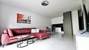 a living room with a red couch and a table at Kolo Apartament in Koło