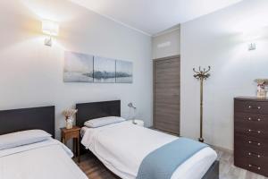 una camera con due letti e un comò di Casa Ugo - Pavia City Center - by Host4U a Pavia